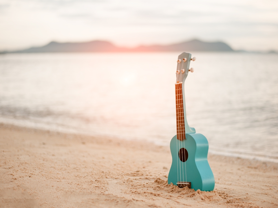 There's a blue guitar stuck in the sand