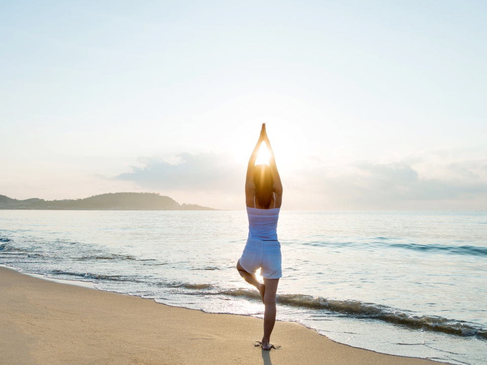 A woman doing yoga on the beach