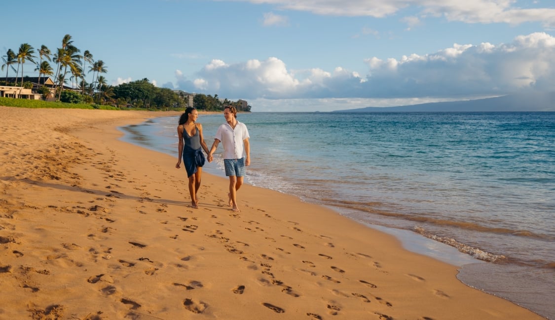 Couple walks on beach