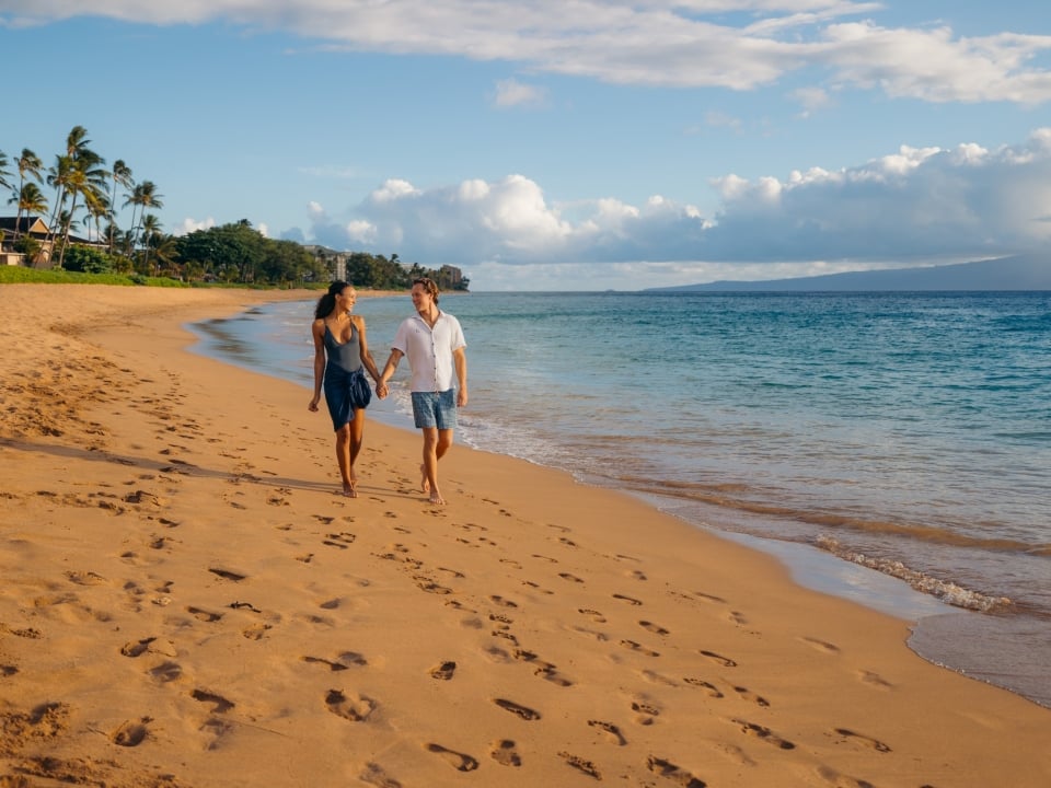 Couple walks on beach