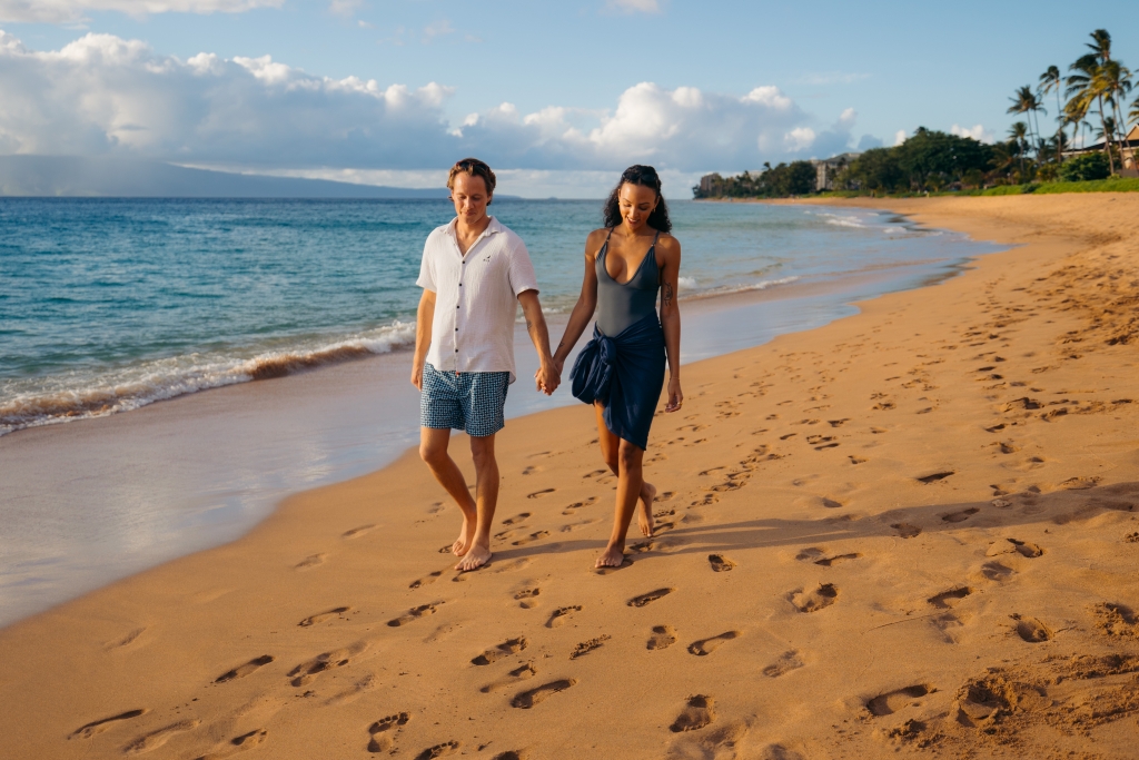 Couple walks on beach