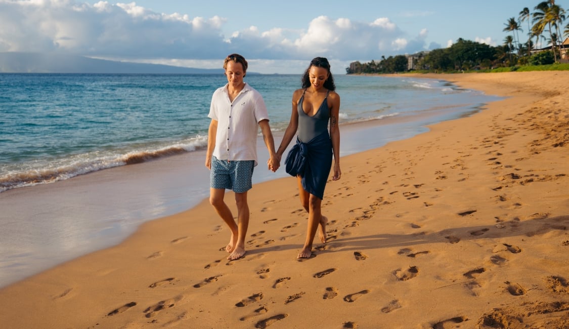 Couple walks on beach