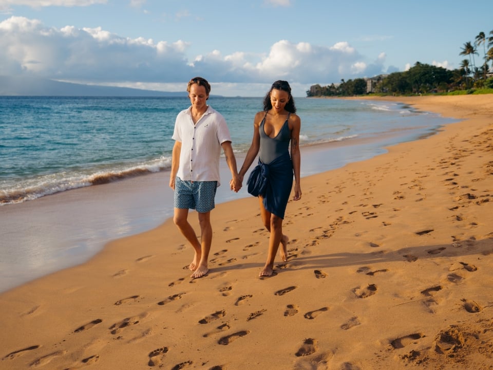 Couple walks on beach